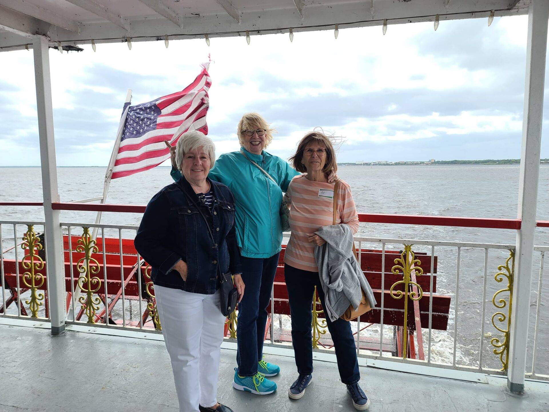 Three LIFE members standing on the deck of the Sanford River Boat